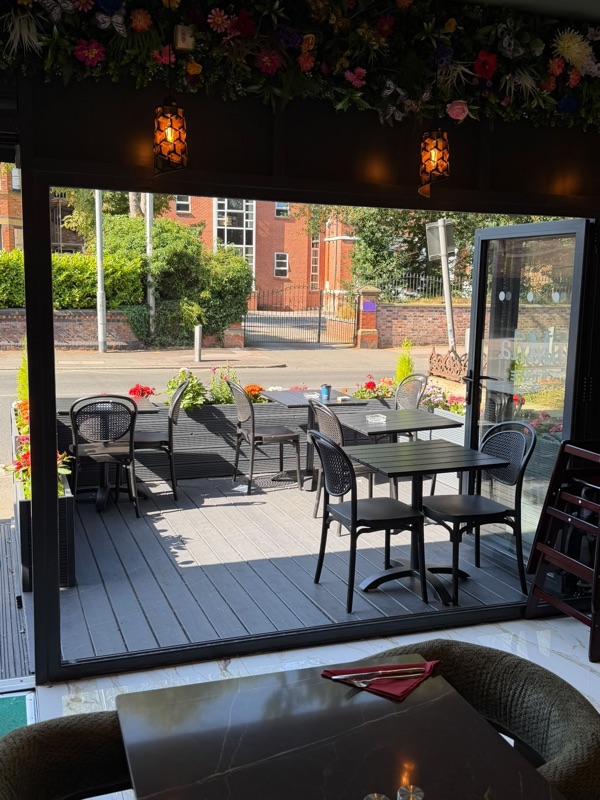 Mila Cafe terrace with tables and flowers